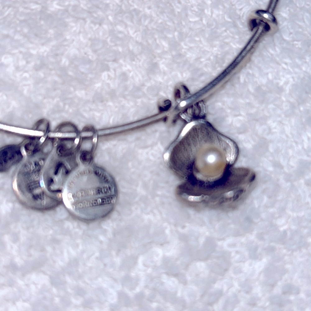 Alex and Ani bangle in silver featuring a Pearl in a oyster shell charm.